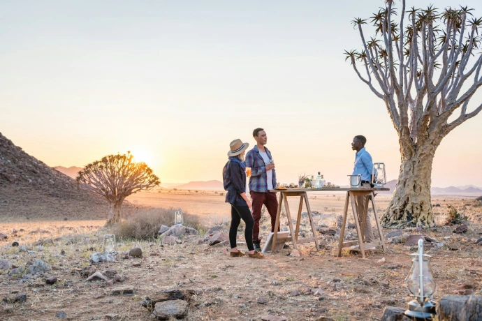a group of people standing around a table in the desert